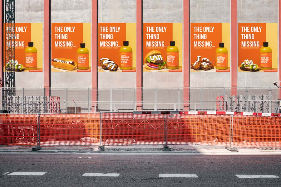 Banana Pepper Sauce Advertisement posters covering construction site